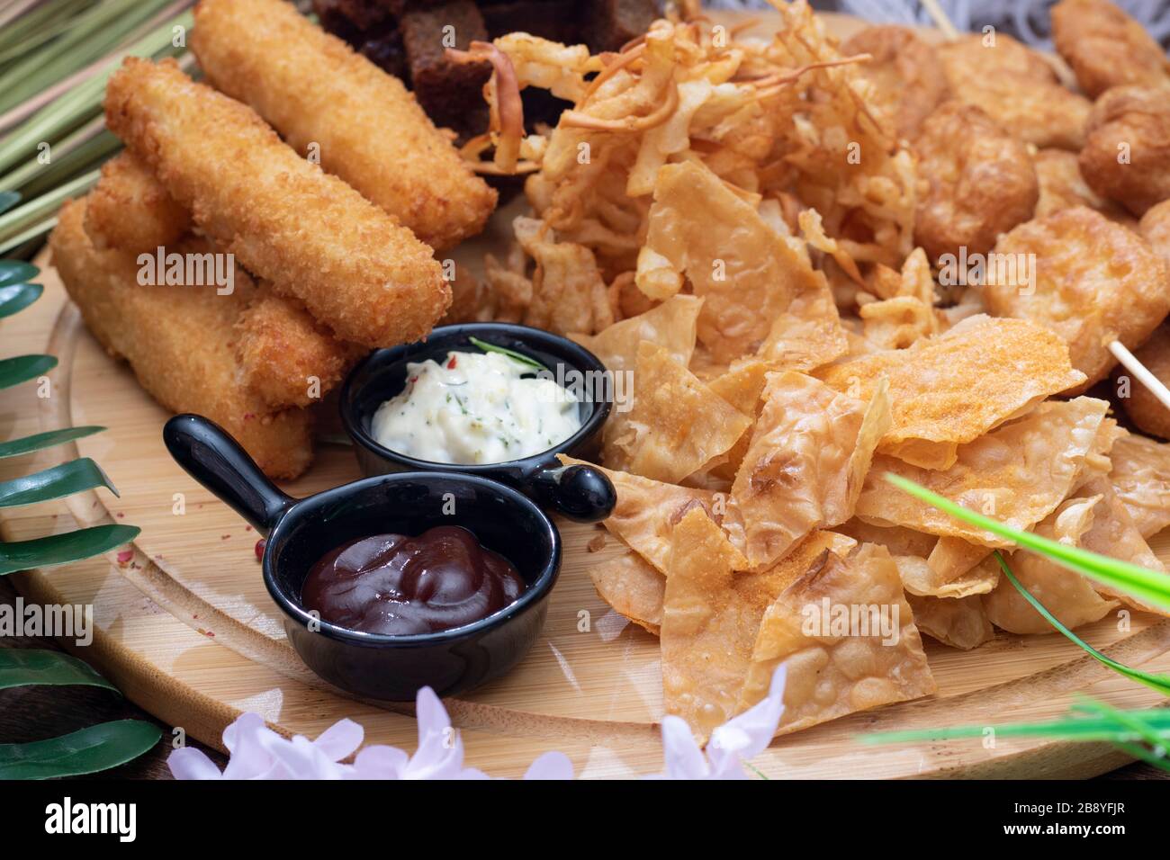 Salty snacks. deried Pretzels, chips, crackers and two sauces Stock Photo