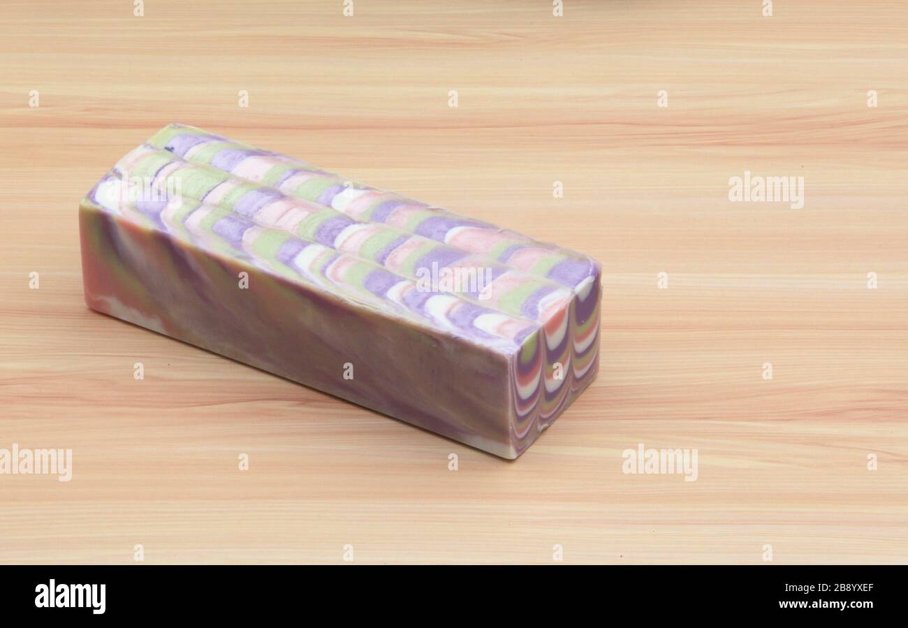 Block of handcrafted soap on wooden surface Stock Photo