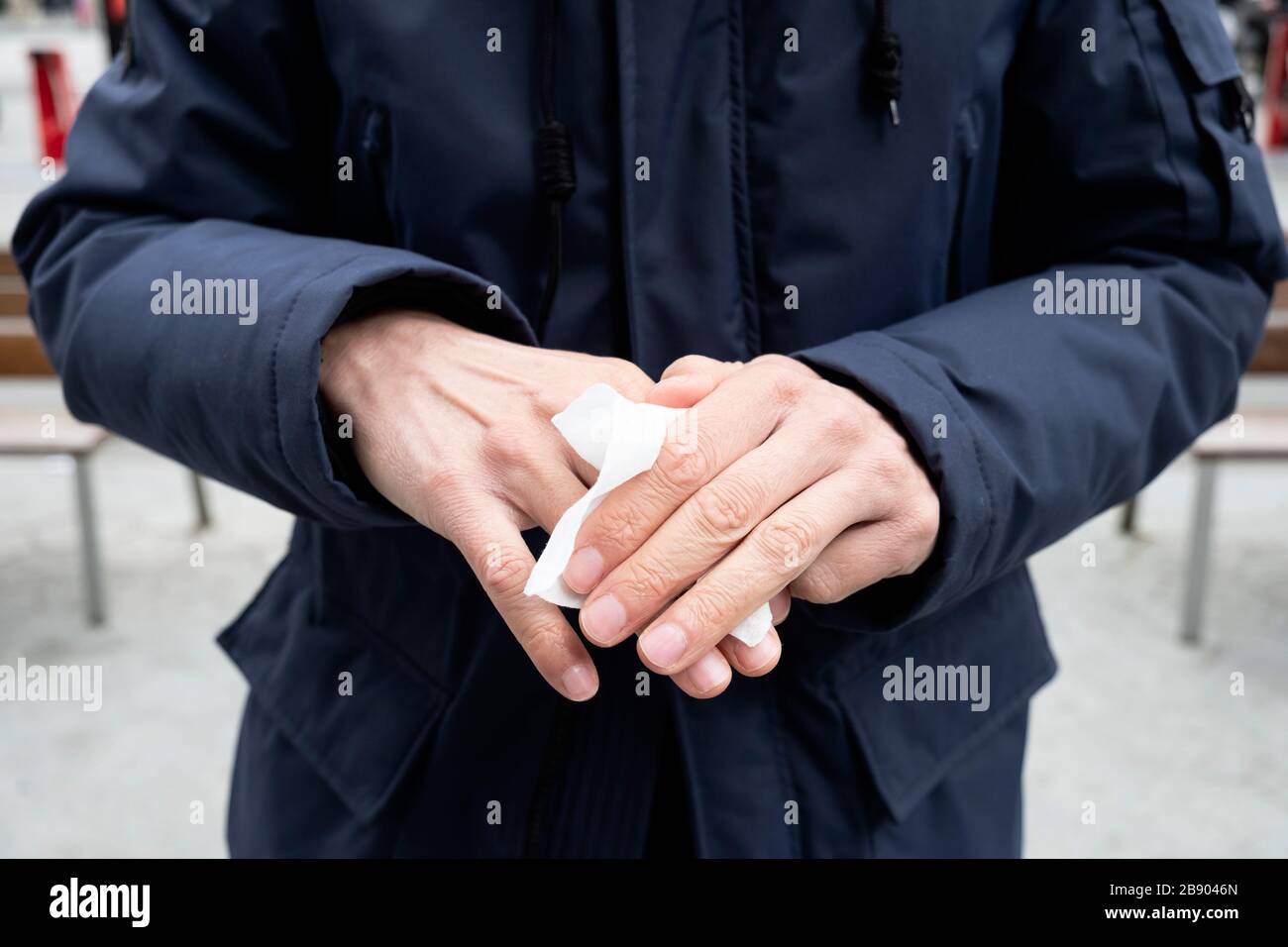 closeup of a caucasian man on the street disinfecting his hands with a wet wipe Stock Photo