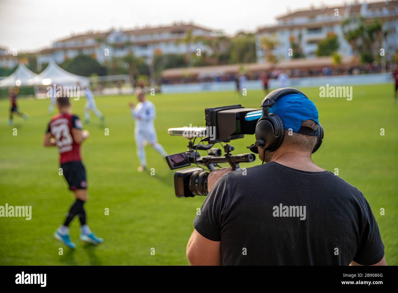 cameraman with camera shooting video on football game Stock Photo Alamy