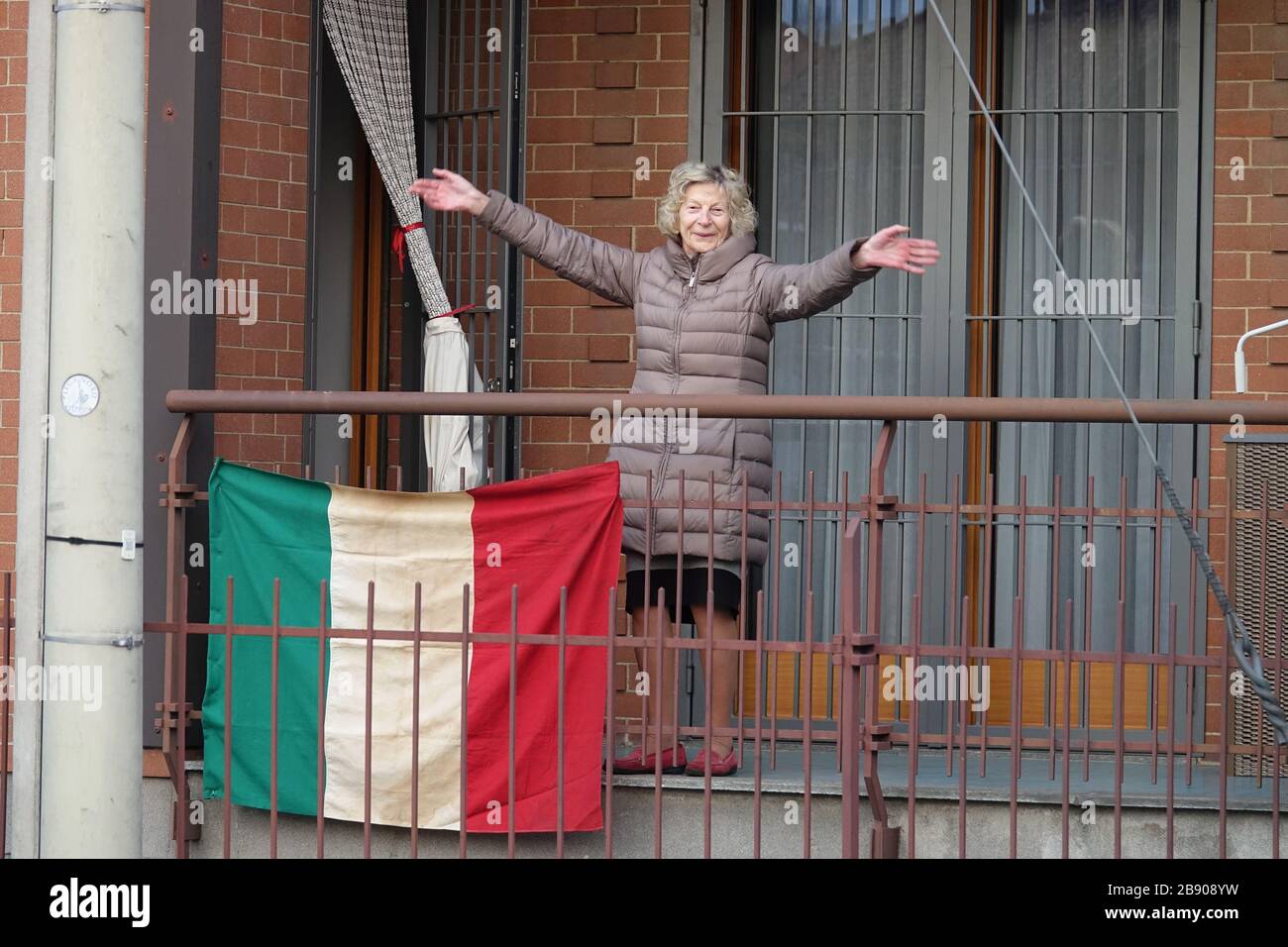 A lady in quarantine on the balcony of the house at the time of covid 19. Milan, Italy - March 2020 Stock Photo