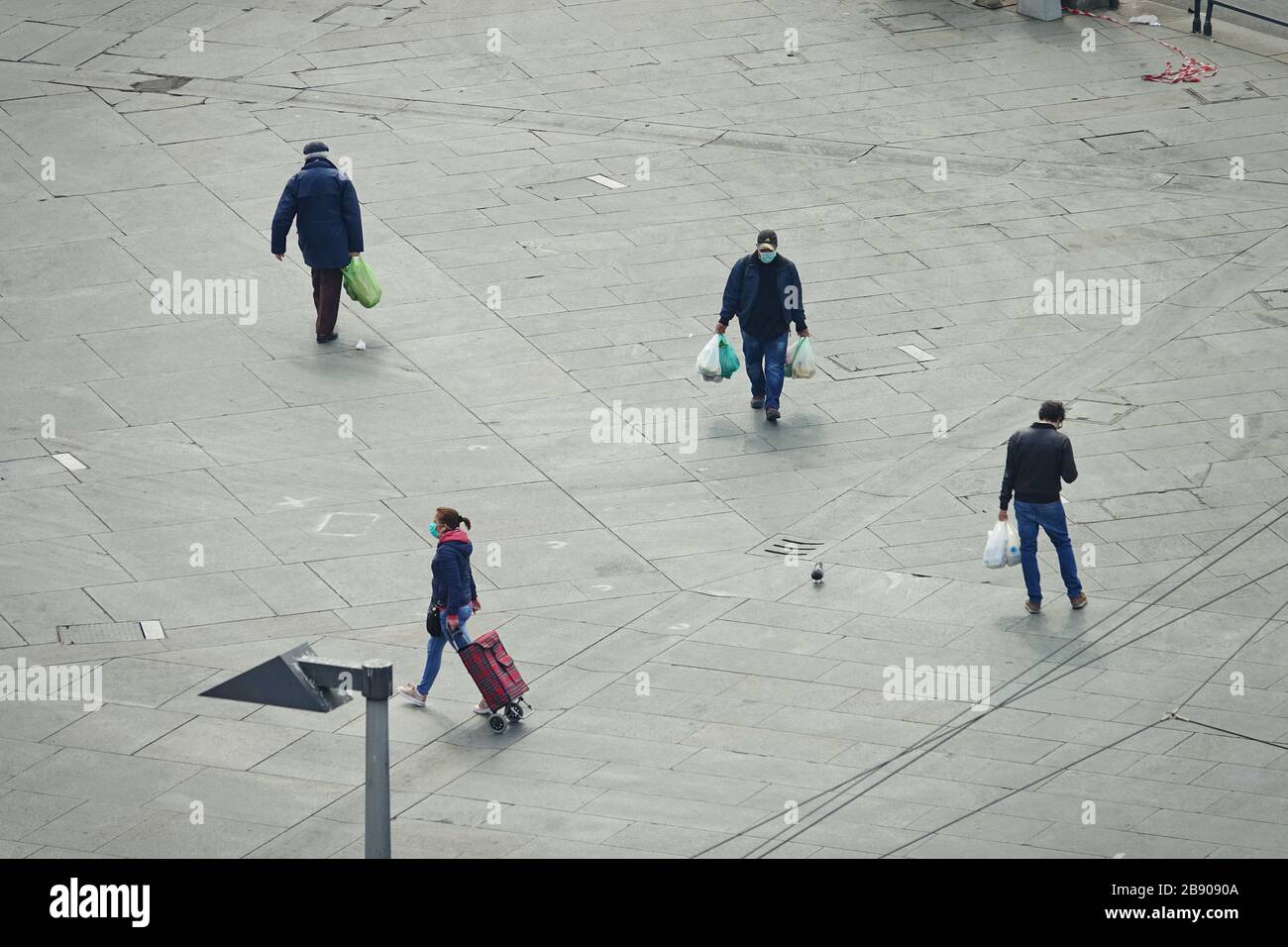 People back from shopping wearing masks to contain the spread of Coronavirus.  Milan, Italy - March 2020 Stock Photo