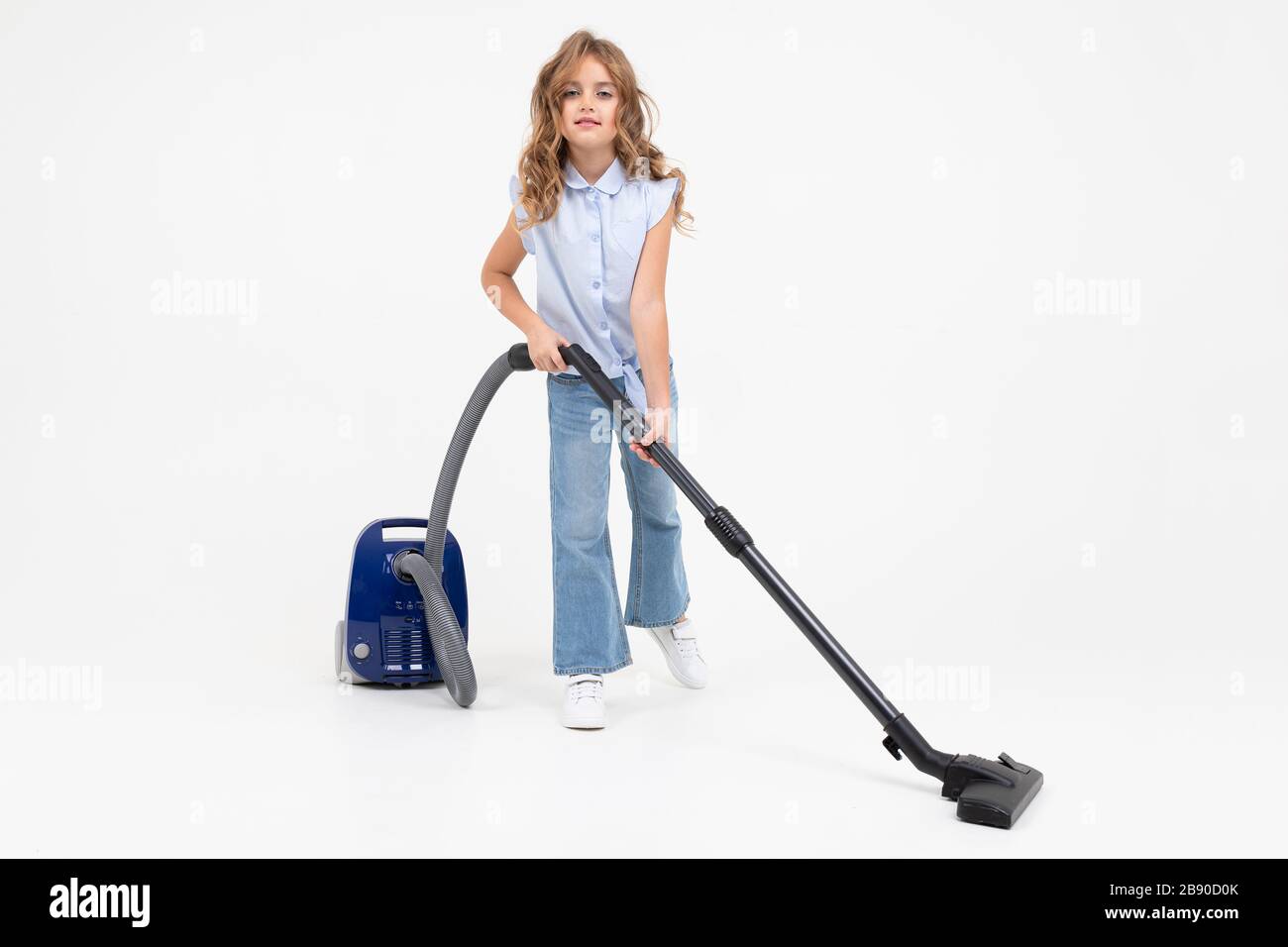 teen girl vacuuming the floor with a vacuum cleaner on an isolated