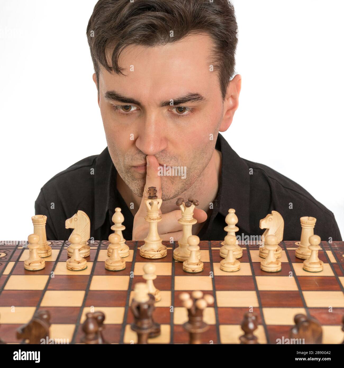 Caucasian man thinking about his second move in a game of chess. Royalty free stock photo. Stock Photo