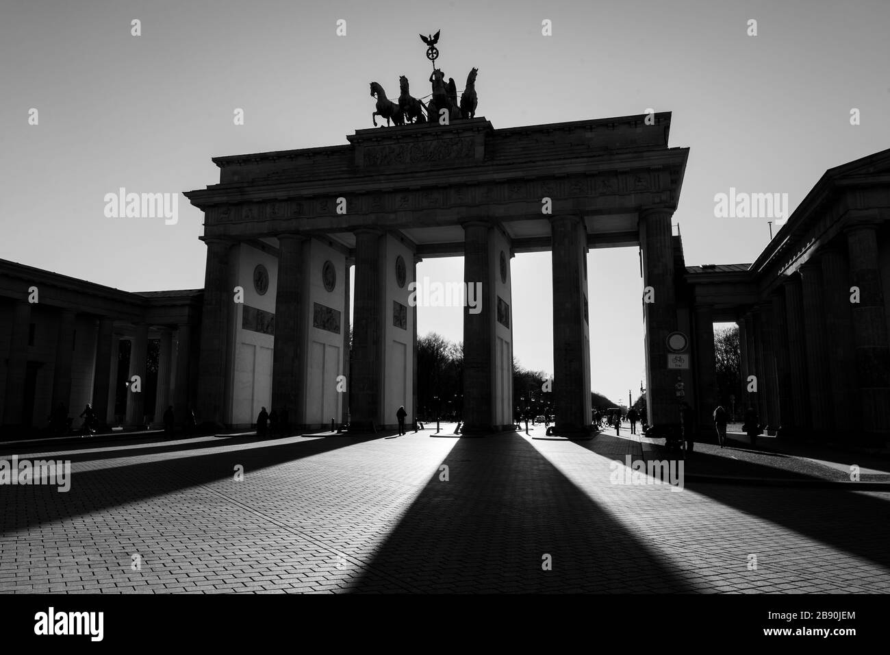 Berlin, Deutschland. 22nd Mar, 2020. 22.03.2020, the Brandenburg goal in Berlin on a late spring juice day in the low sun. The sun shines through the prophylaxis and creates a special mood of light and long shadows. Due to the corona crisis, only a few people are on the streets and squares in Berlin. | usage worldwide Credit: dpa/Alamy Live News Stock Photo