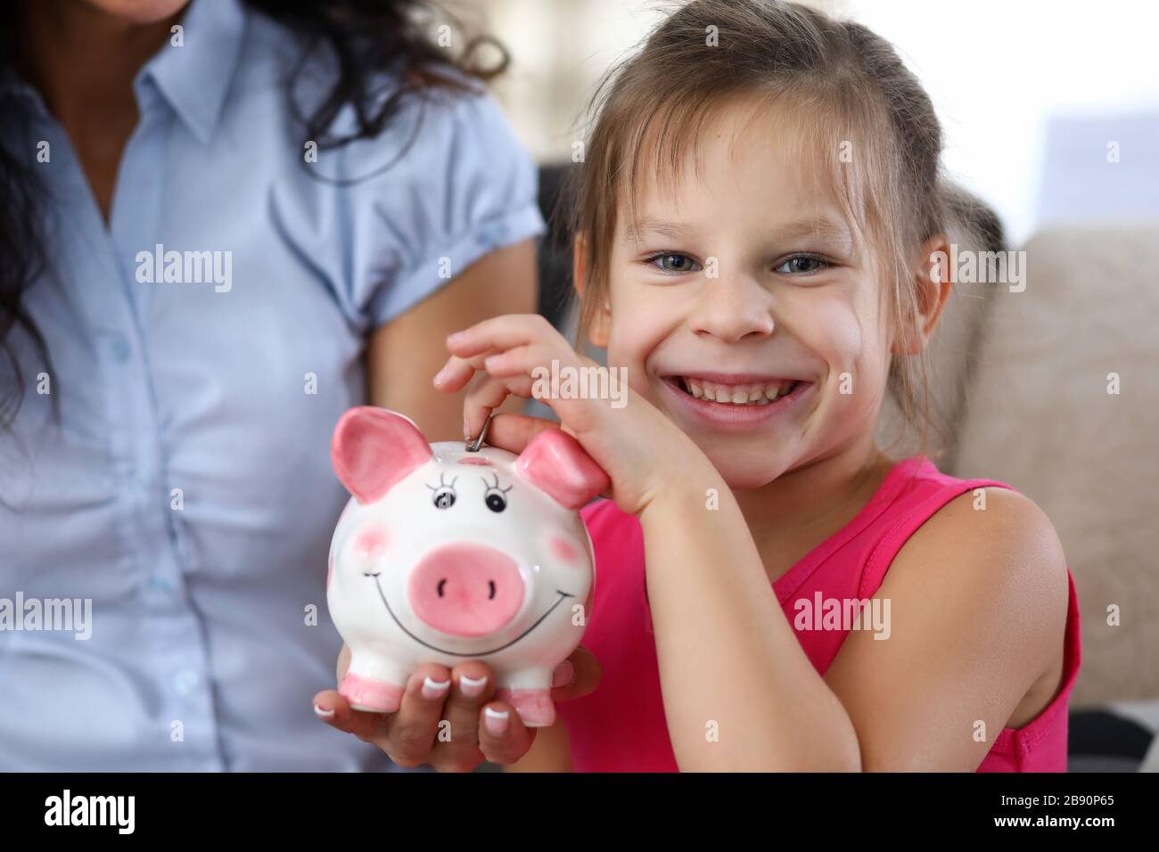 Child putting coin in thrift-box Stock Photo