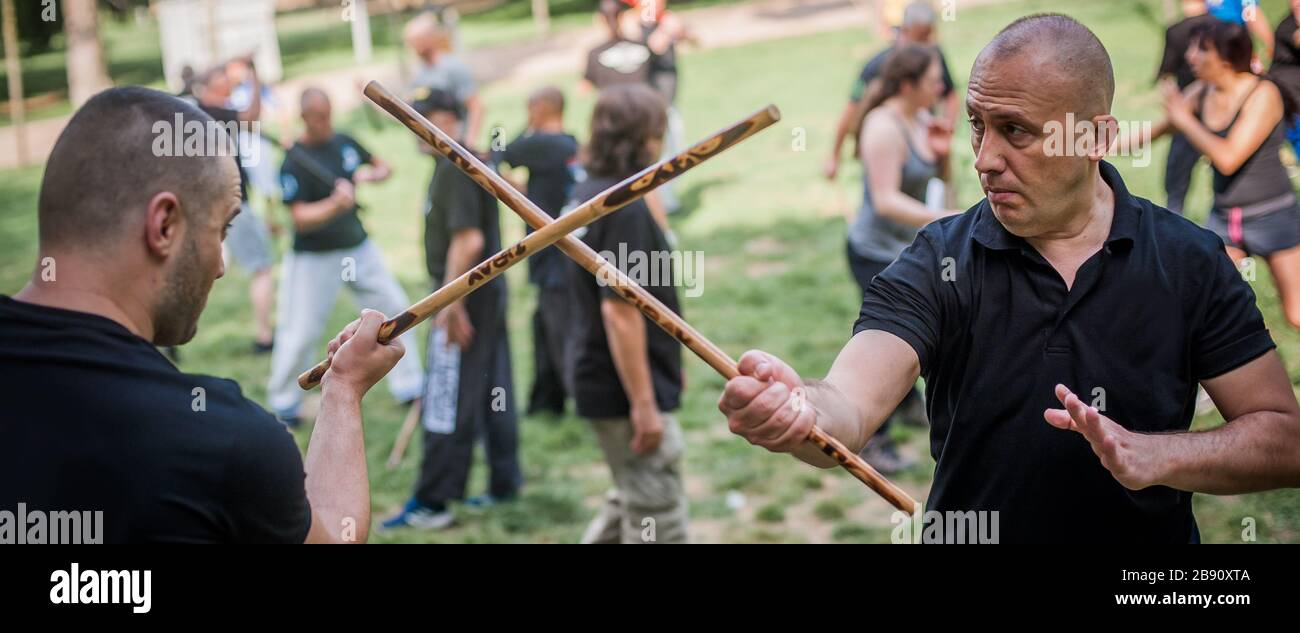 Large group of students practice filipino eskrima arnis stick