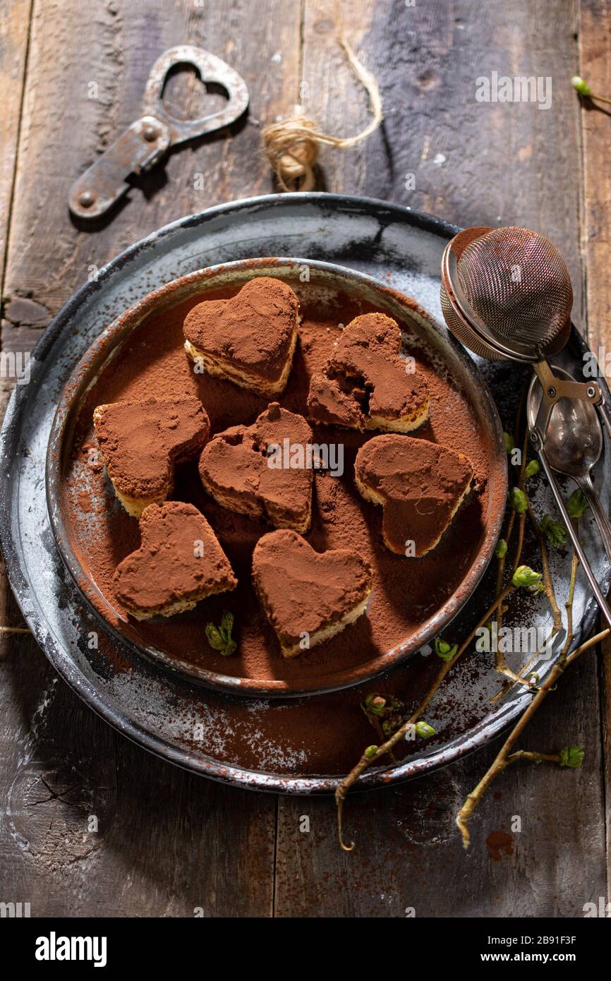Sweet chocolate hearts.Vintage style.Cookies on a plate on a old table.Healthy food and drink Stock Photo