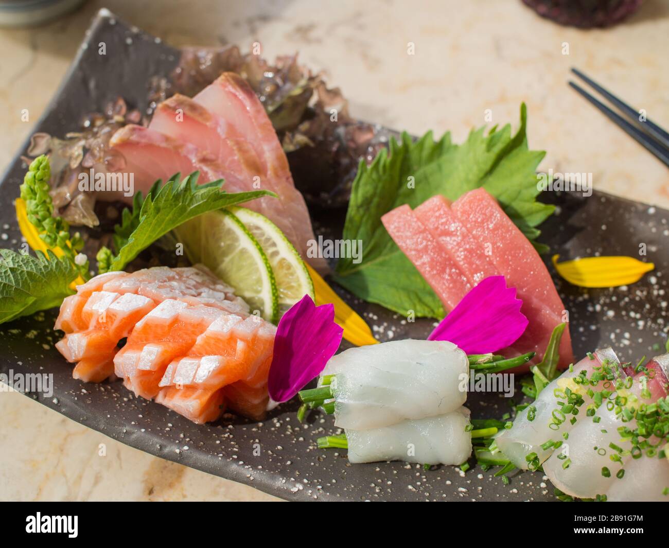 Juldom Fish Japanese raw fish on black plate. Also known as Sashimi Stock Photo - Alamy