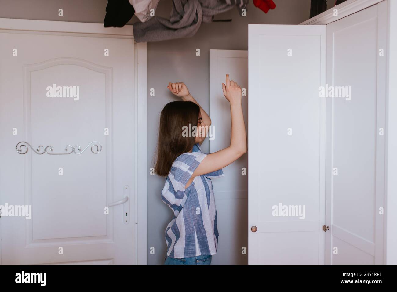 A teenage girl throws clothes out of her closet Stock Photo Alamy