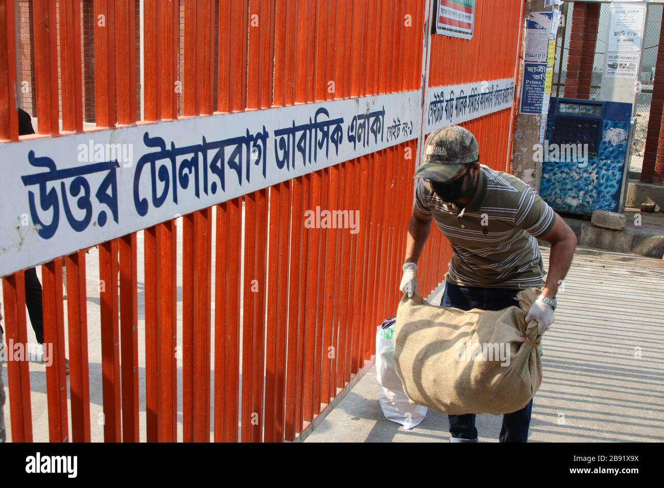 A man seen passing foods in front of locked down area amid Coronavirus fears in Dhaka.Bangladesh has reported its third death from Covid-19, a new strain of coronavirus, infection. Six new Covid-19 patients were confirmed by Institute of Epidemiology, Disease Control and Research (IEDCR). As of now, a total of 33 cases have been confirmed. Stock Photo