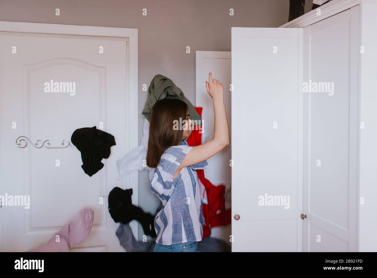 https://c8.alamy.com/comp/2B921FD/a-teenage-girl-throws-clothes-out-of-her-closet-2B921FD.jpg