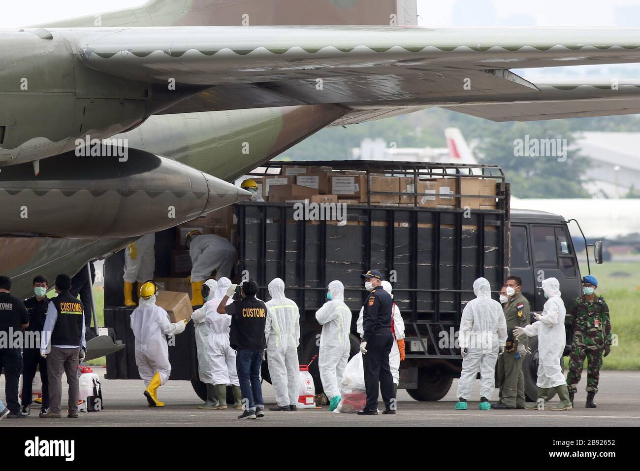 Jakarta, Indonesia. 23rd Mar, 2020. Indonesian health officers load medical supplies onto a truck at a military air base in Jakarta, Indonesia, March 23, 2020. Indonesian Defense Minister Prabowo Subianto on Monday handed over the medical devices from China to representatives of hospitals which are designated to treat COVID-19 patients in the country. Credit: Wijoyo/Xinhua/Alamy Live News Stock Photo