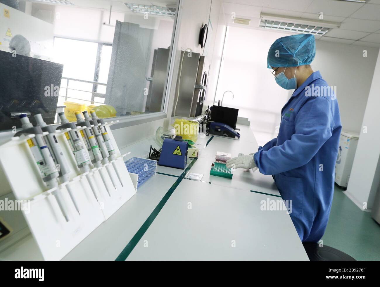 Shanghai, China. 23rd Mar, 2020. A staff prepares the testing reagent in Shanghai KingMed Diagnostics in Shanghai, east China, March 23, 2020. Shanghai ordered people arriving in the city from other countries to undergo nucleic acid testing (NAT) to screen for coronavirus from Monday, local authorities said. The new measure will expand a program that previously only applied to those coming from 24 heavily-hit countries, no matter their nationality, according to the municipal government's press conference on Sunday. Credit: Liu Ying/Xinhua/Alamy Live News Stock Photo