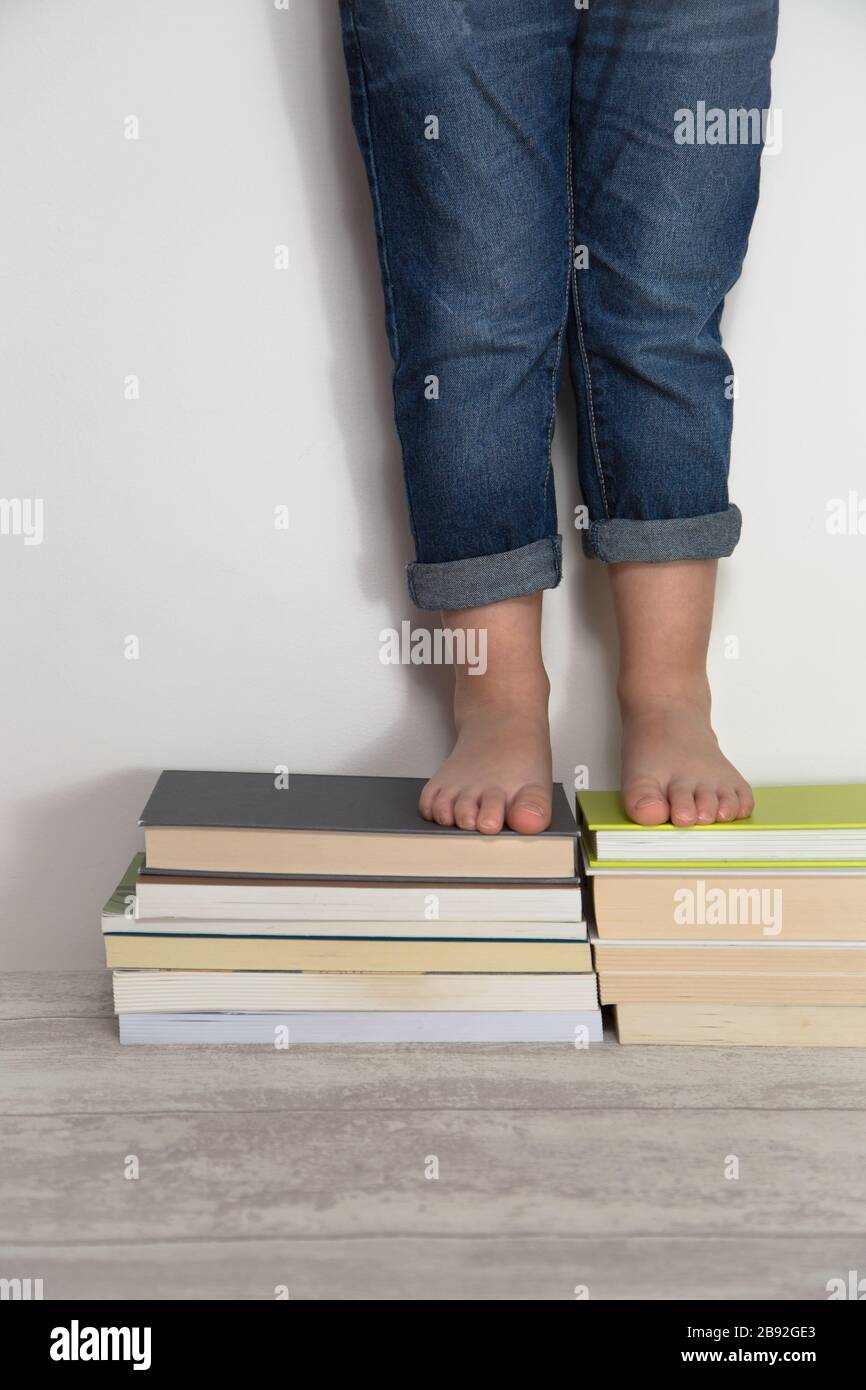 child standing on stacks of books. World book day concept Stock Photo