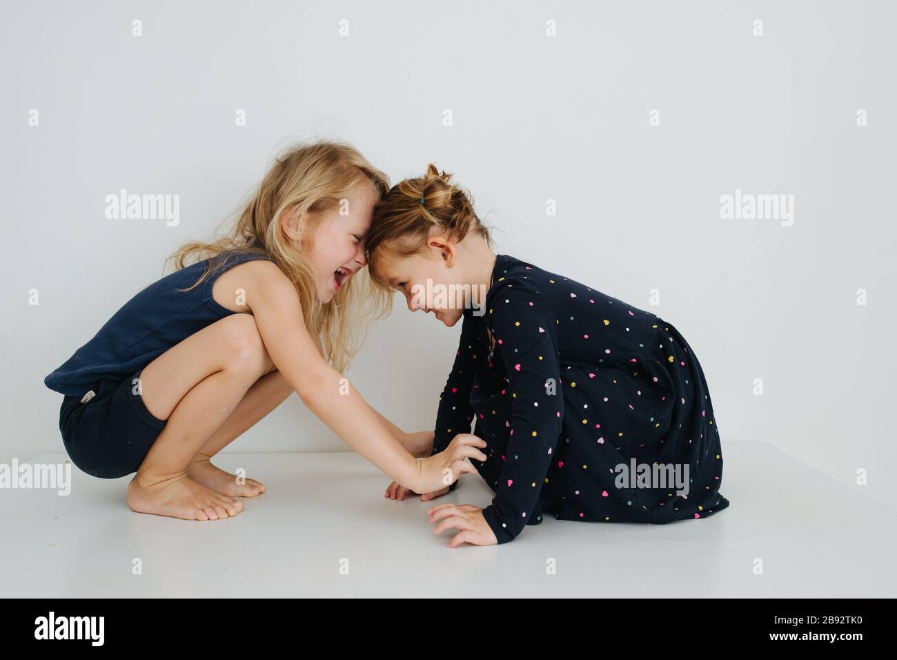 Sibling buried their foreheads at each other Stock Photo