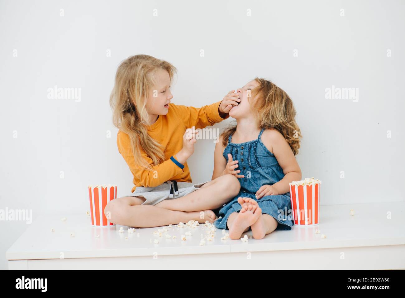 Sibling have fun feeding each other popcorn Stock Photo