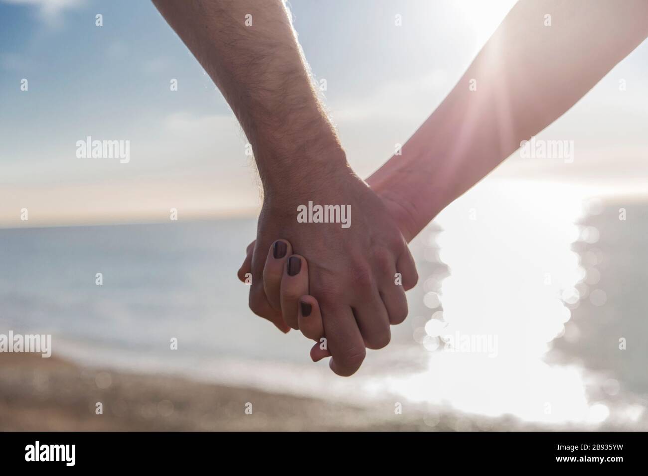 Couple Holding Hands By The Sea Stock Photo - Alamy