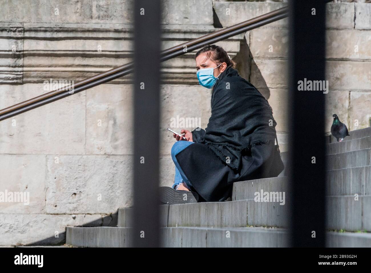 London, UK. 23rd Mar 2020. No Lock down as yet - St Paul's Cathedral is closed but a few people still enjoy the sun on the steps - Anti Coronavirus (Covid 19) outbreak in London. Credit: Guy Bell/Alamy Live News Stock Photo