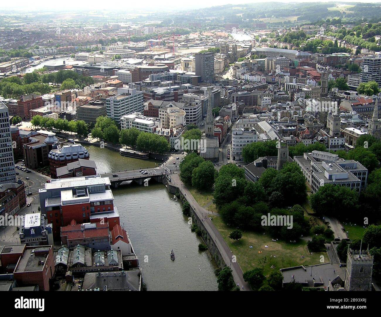 'The River Avon flows through the centre of Bristol, England. Portions of the true river can also be seen top left, and towards the top of the picture at centre right Centre left is Bristol Bridge, with four cars on it. In the bottom left corner are the red-tiled roofs of the former Georges Brewery, bordering the river. The buildings are now flats. Bottom right is the greenery  of Castle Park with people sunbathing. The hills at top right include Ashton Park where the Bristol Balloon Fiesta is held. The picture was taken from a tethered passenger balloon, 500 feet up.; 16 July 2005; Photograph Stock Photo