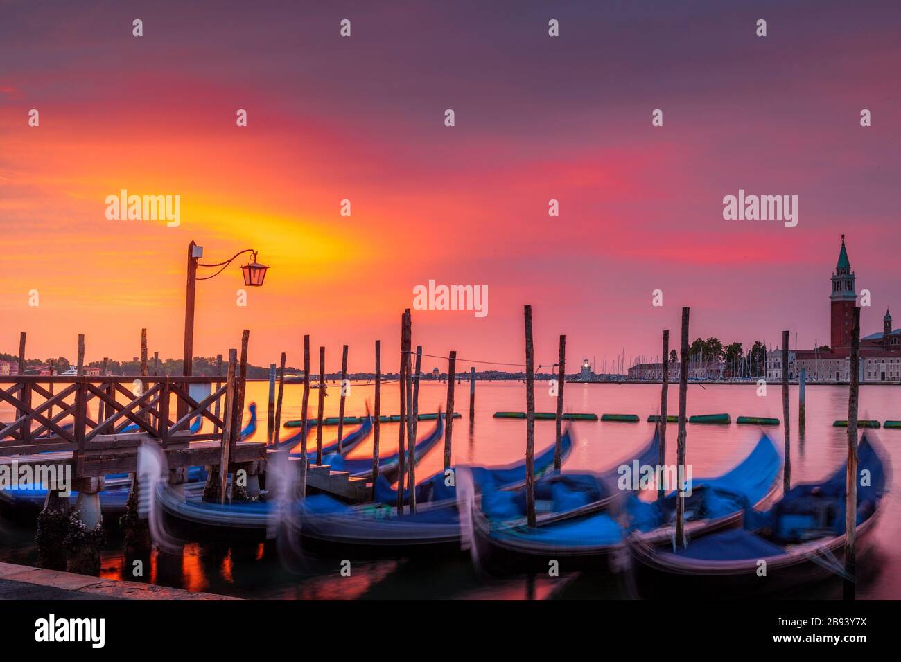 Dawn over the Grand Canal seen from St. Mark's Square in Venice, Italy.  Seen in the foreground are parked gondolas and in back is San Giorgio island Stock Photo