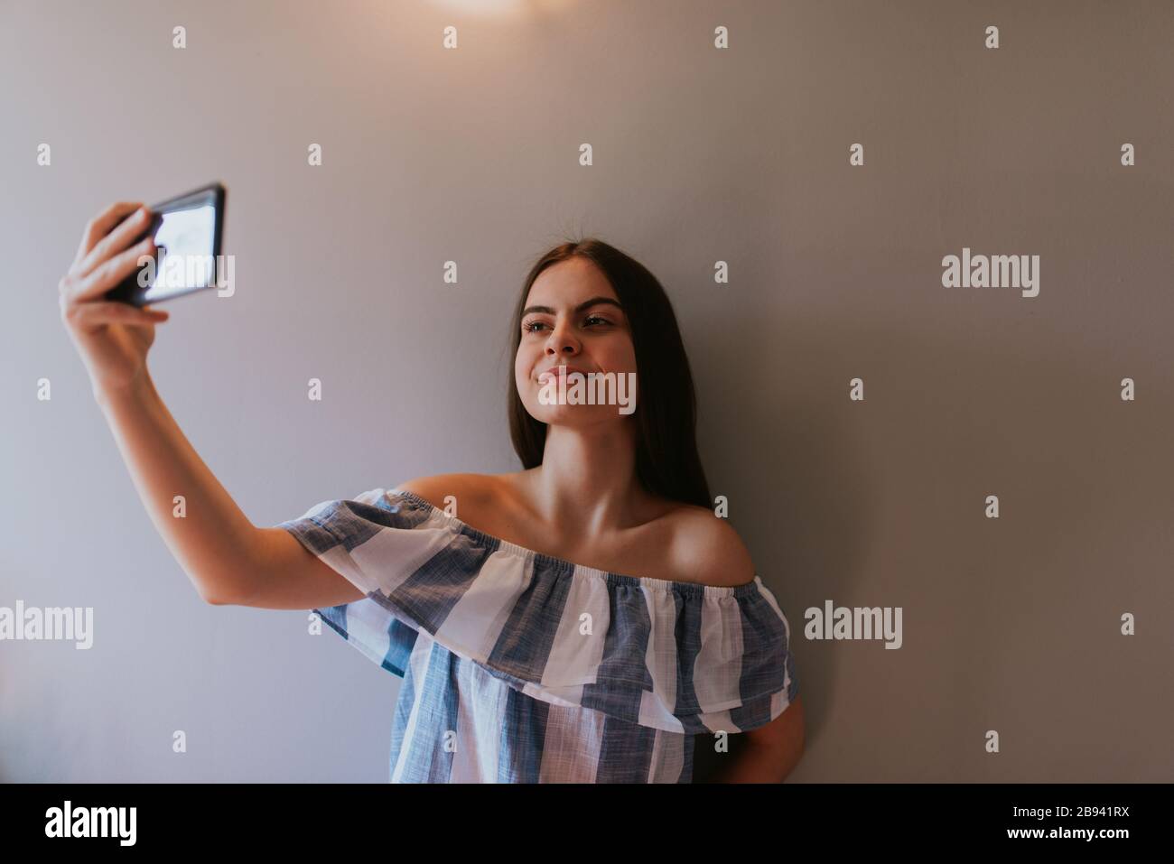 A teenage girl with a phone makes selfies in her room Stock Photo - Alamy