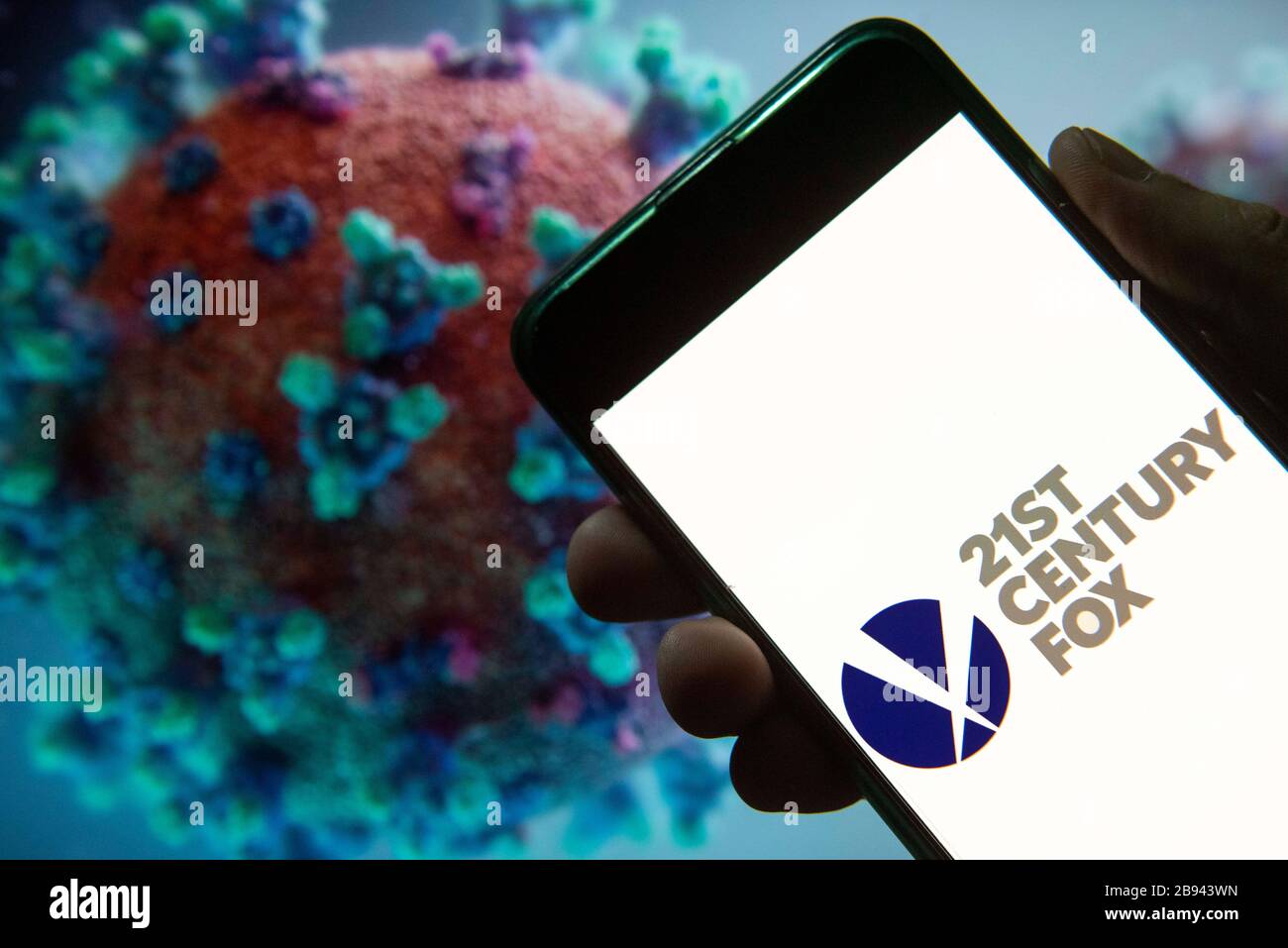China. 20th Mar, 2020. In this photo illustration the American multinational mass media corporation Twenty-First 21st Century Fox logo seen displayed on a smartphone with a computer model of the COVID-19 coronavirus on the background. Credit: Budrul Chukrut/SOPA Images/ZUMA Wire/Alamy Live News Stock Photo