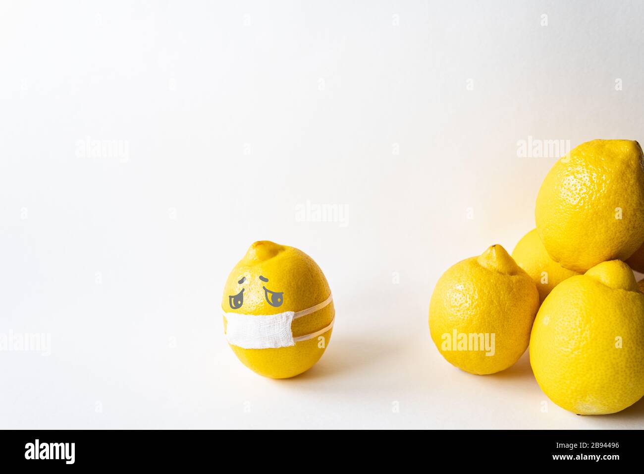 Lemon wearing medical mask isolated from the crowd. Conceptual image of social distancing. Stock Photo
