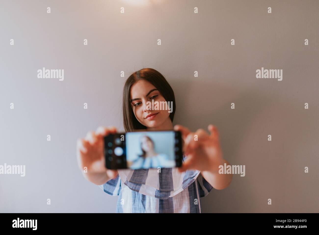 A teenage girl with a phone makes selfies in her room Stock Photo - Alamy