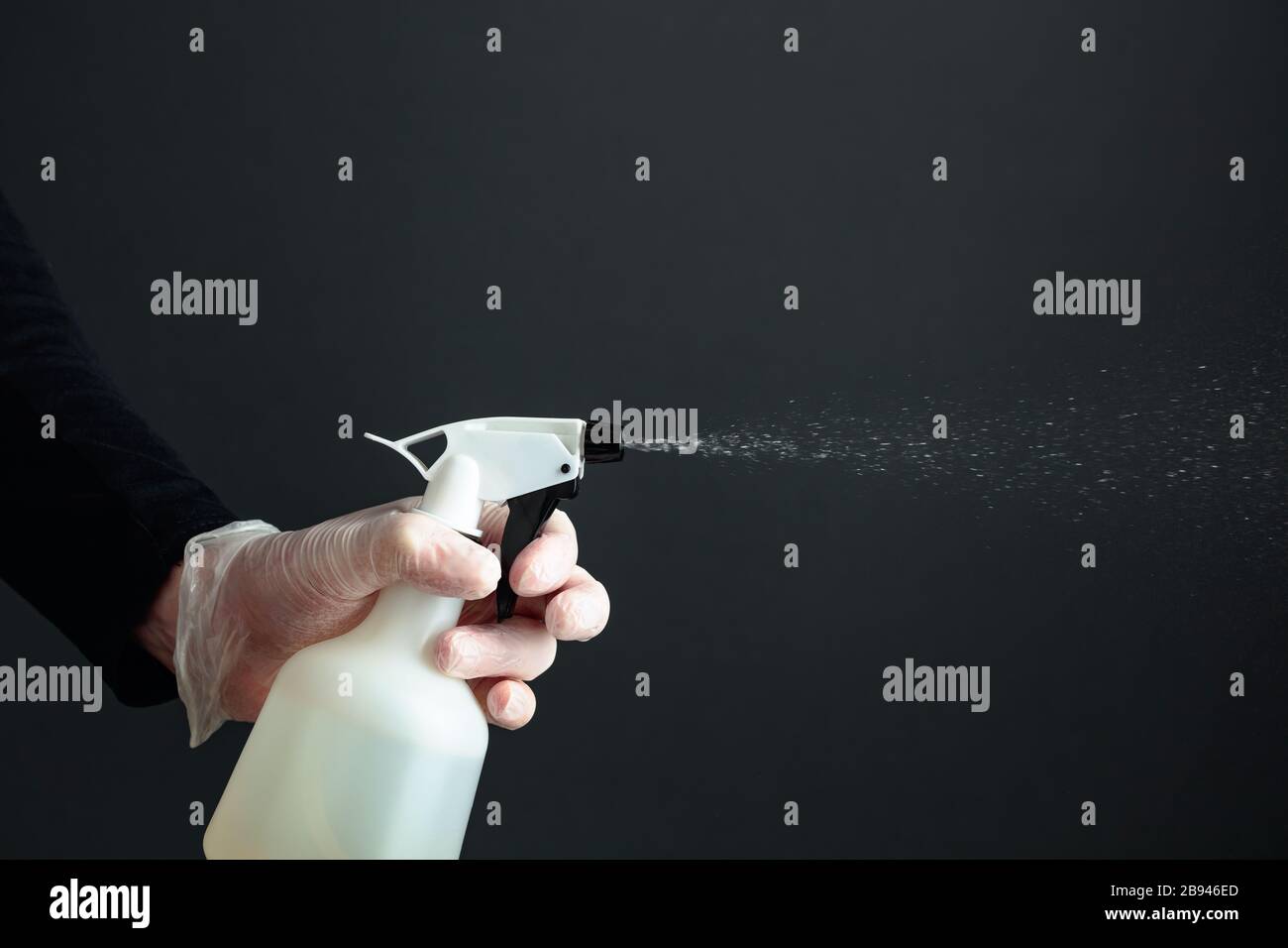 Man's hand in rubber glove sprays disinfectant, copy space Stock Photo
