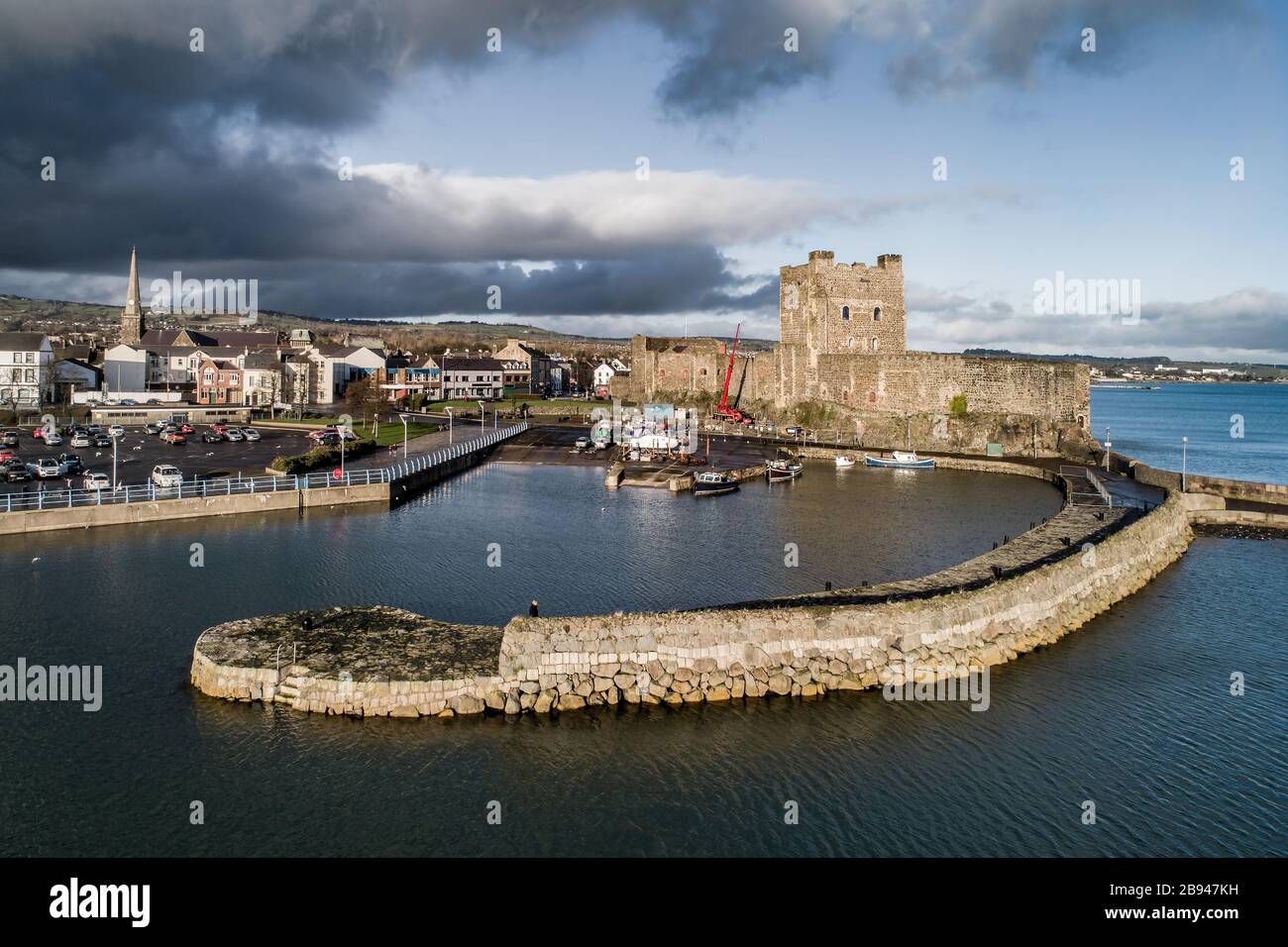 Medieval Norman Castle, harbor with boat ramp and wave breaker in Carrickfergus near Belfast