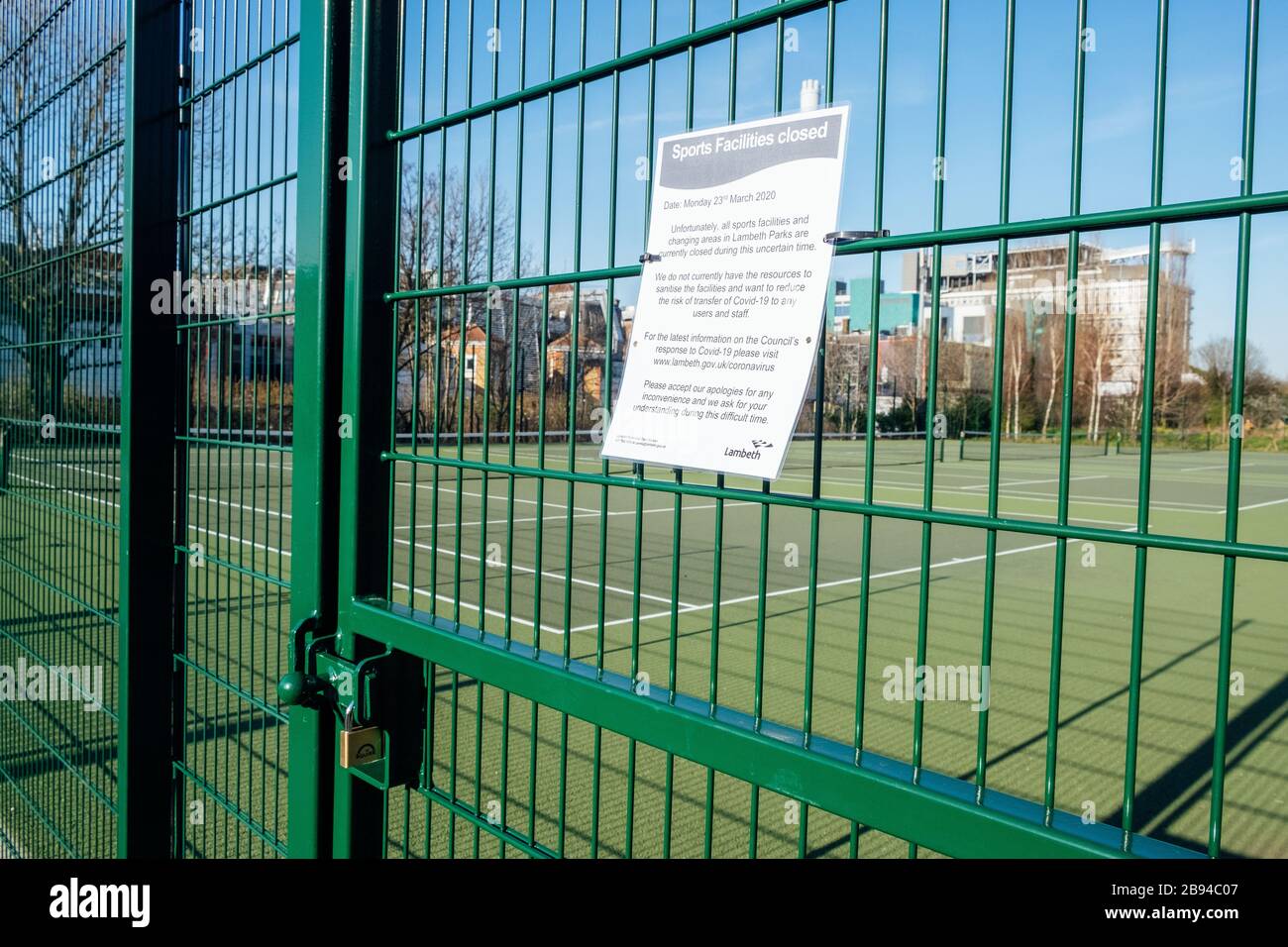 Ruskin Park, Camberwell, London, UK. 23rd March, 2020. Tennis courts with a view of King's College Hospital in the background are locked to prevent the spread of coronavirus. Lambeth Council have closed all sports facilities and playgrounds as they do not have the resources to sanitise the facilities sufficiently. Credit: Tom Leighton/Alamy Live News Stock Photo