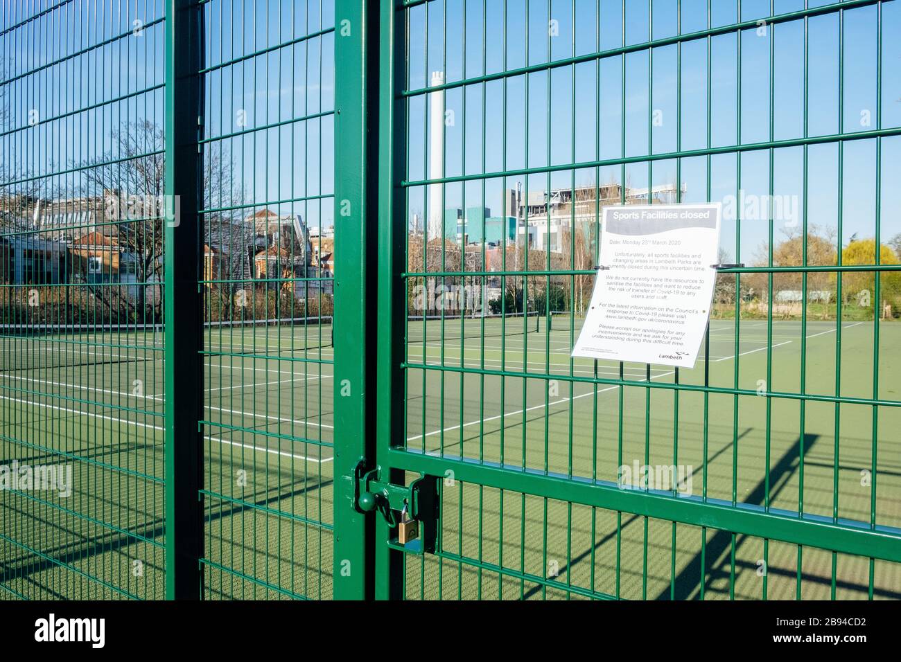 Ruskin Park, Camberwell, London, UK. 23rd March, 2020. Tennis courts with a view of King's College Hospital in the background are locked to prevent the spread of coronavirus. Lambeth Council have closed all sports facilities and playgrounds as they do not have the resources to sanitise the facilities sufficiently. Credit: Tom Leighton/Alamy Live News Stock Photo