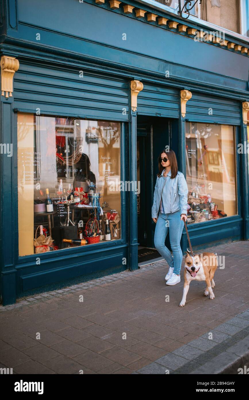 A beautiful young girl is walking her dog on the street Stock Photo - Alamy