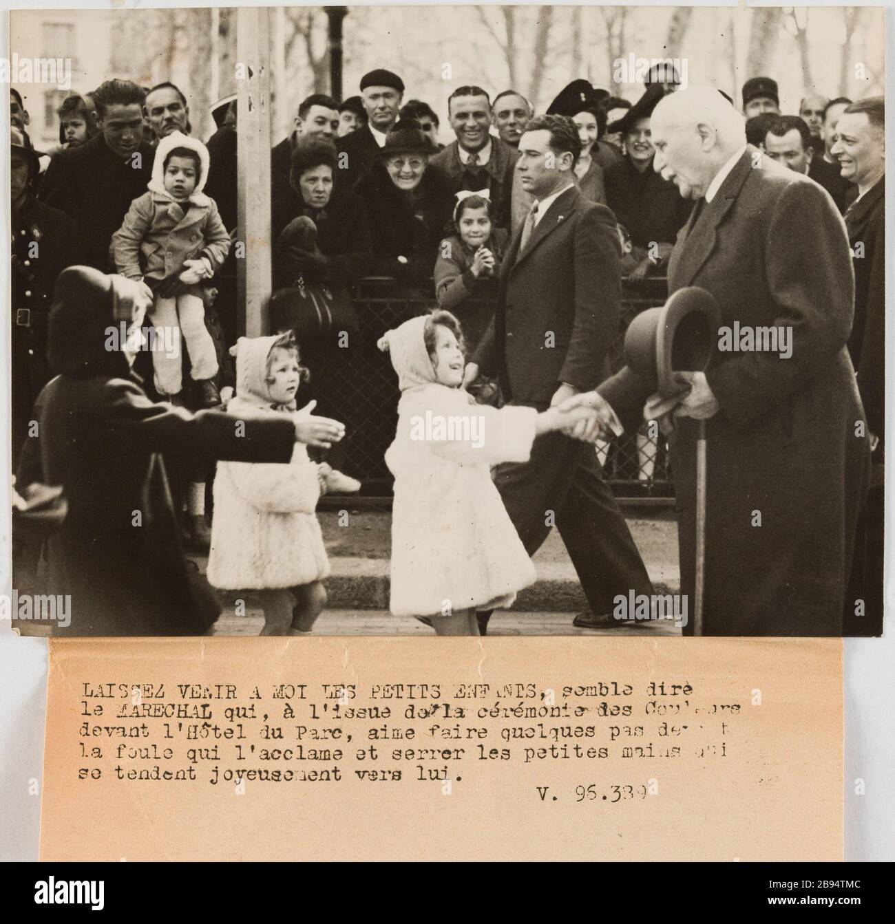 Photography propaganda Petain greets children, Hotel du Parc, Vichy Champroux, Georges. 'Photographie propagande : Pétain salue des enfants, hôtel du Parc, Vichy'. LAISSEZ VENIR A MOI LES PETITS ENFANTS, semble dire / le MARECHAL qui, à l'issue de la cérémonie des Couleurs / devant l'Hôtel du Parc, aime faire quelques pas devant / la foule qui l'acclame et serrer les petites mains qui / se tendent joyeusement vers lui. / V.96.389. Tirage au gélatino-bromure d'argent. Légende dactylographiée à l'encre noire. en 1944-04-03-1944-04-03. Paris, musée Carnavalet. Stock Photo