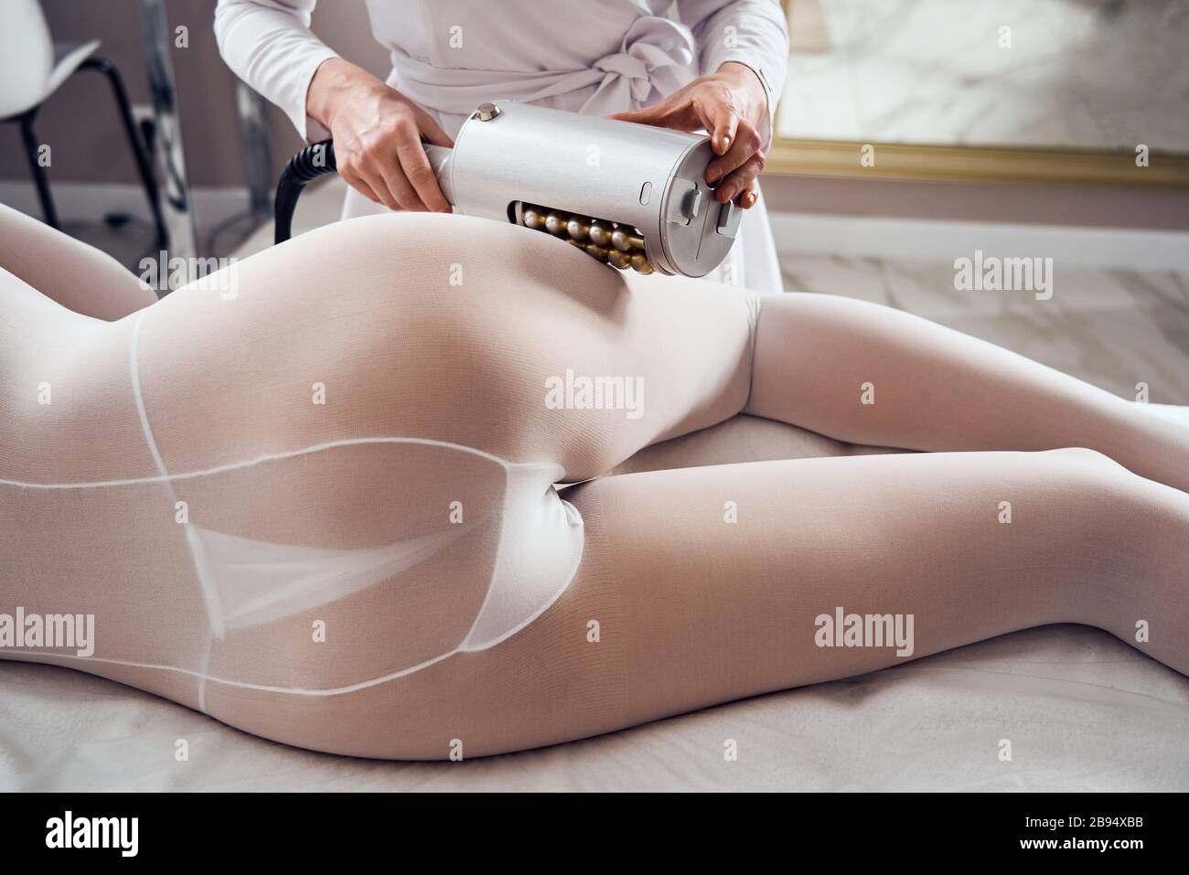 Masseur makes apparatus anti-cellulite massage in the cosmetology clinic Stock Photo