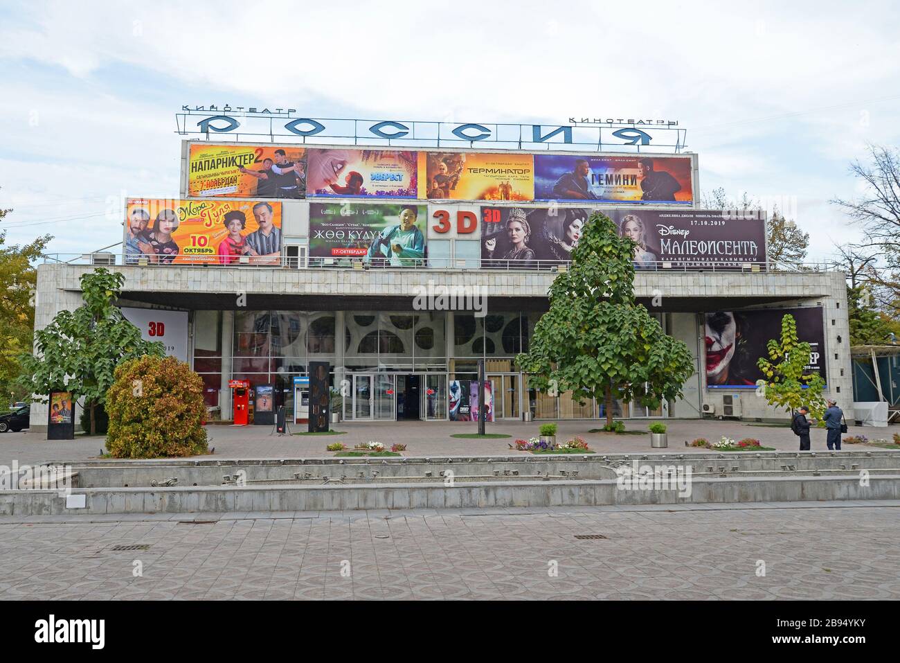 Exterior view of a Kyrgyz cinema built in the USSR times in Bishkek, Kyrgyzstan. Russia written in Cyrillic. Soviet architecture style. Kino Theater. Stock Photo