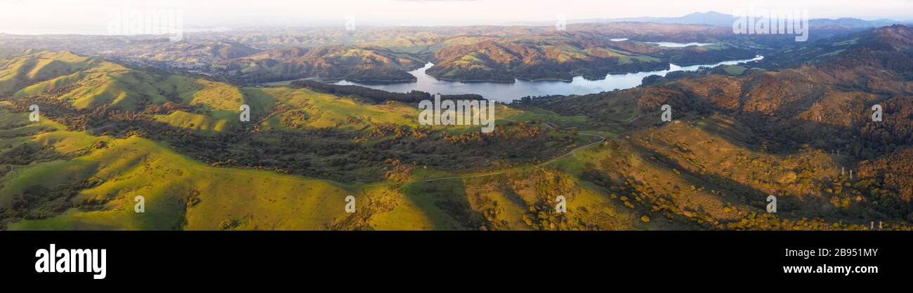Evening sunlight shines on the green hills of the East Bay in Northern California. This open area, east of San Francisco Bay, is green in the winter. Stock Photo
