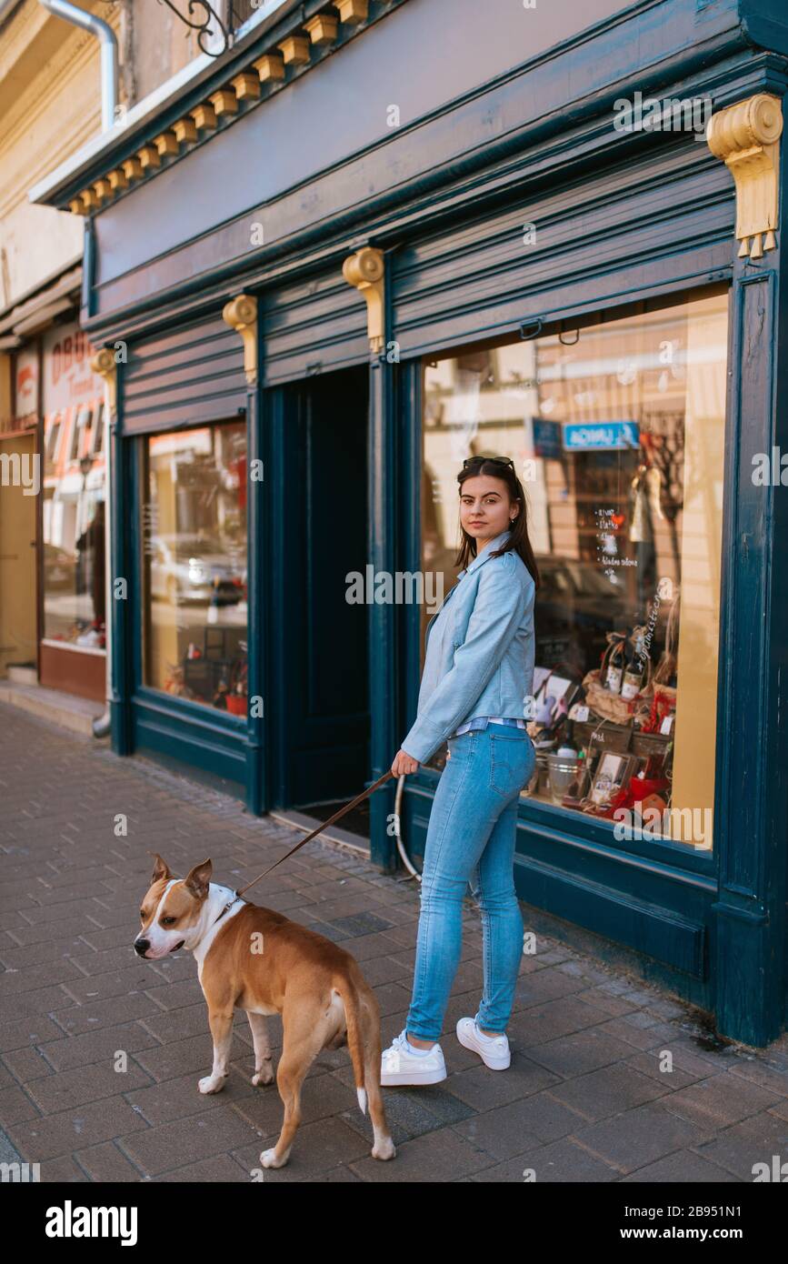 A beautiful young girl is walking her dog on the street Stock Photo - Alamy