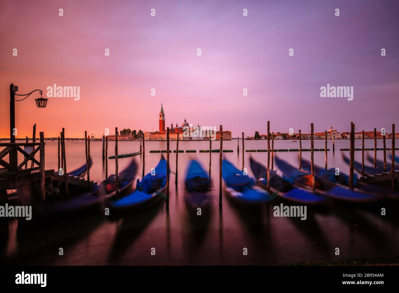 Dawn over the Grand Canal seen from St. Mark's Square in Venice, Italy.  Seen in the foreground are parked gondolas and in back is San Giorgio island Stock Photo