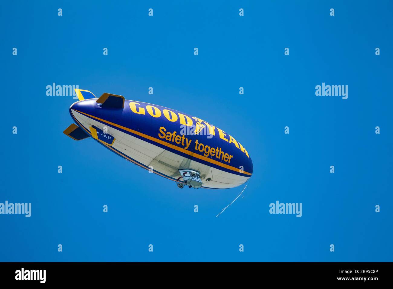 The Good Year airship (blimp) flying over West Yorkshire, U.K. against a clear blue sky en route to televise a sports event Stock Photo