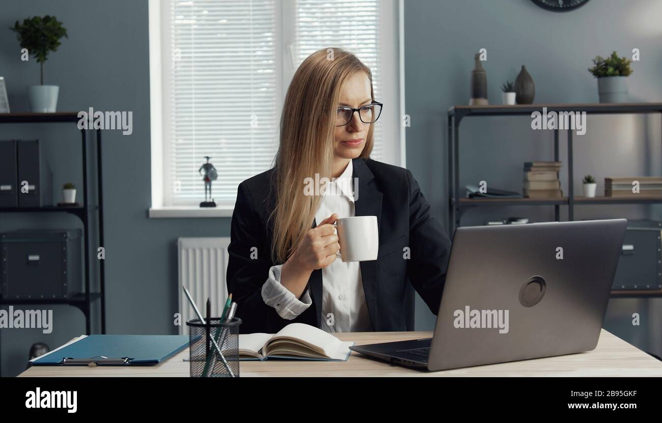 Businesswoman having coffee while working Stock Photo