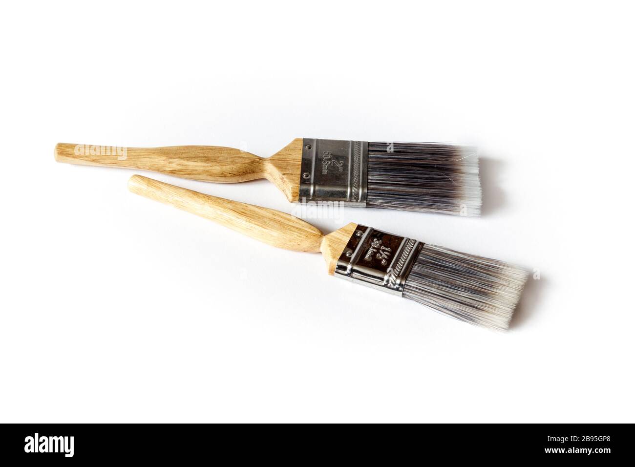 Two wooden-handled nylon-bristled paint brushes against a white background Stock Photo