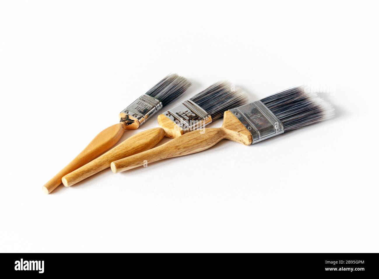 Three wooden-handled nylon-bristled paint brushes against a white background Stock Photo
