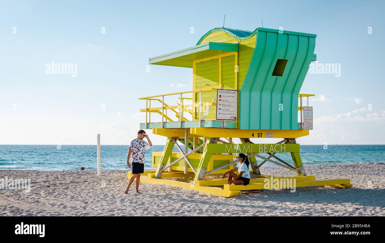 Miami beach Florida, young men on the beach with colorful lifeguard hut,  man walking on the beach in Miami during vacation Stock Photo - Alamy