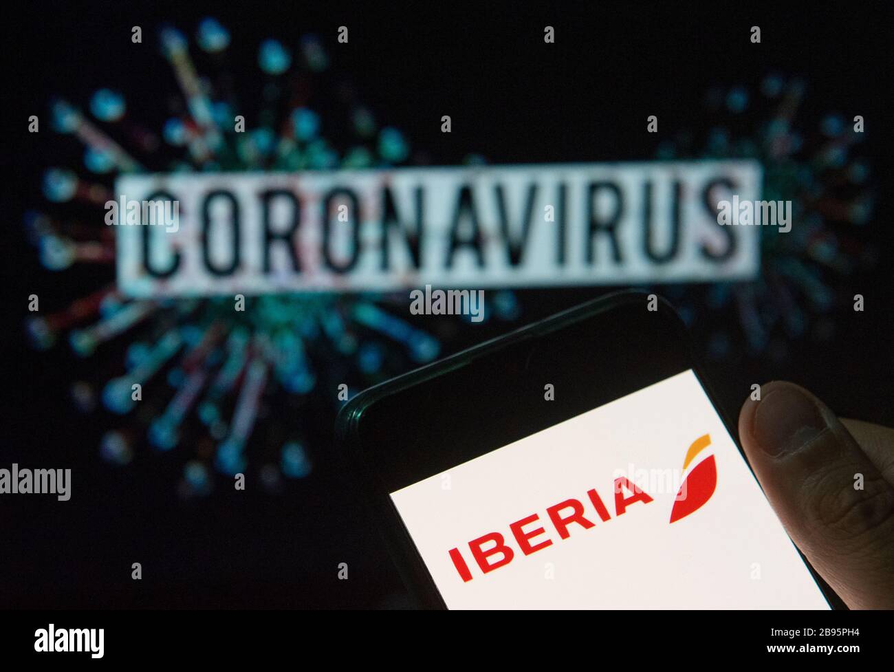 In This Photo Illustration The Spanish Iberia Airline Logo Seen Displayed On A Smartphone With A Computer Model Of The Covid 19 Coronavirus On The Background Stock Photo Alamy