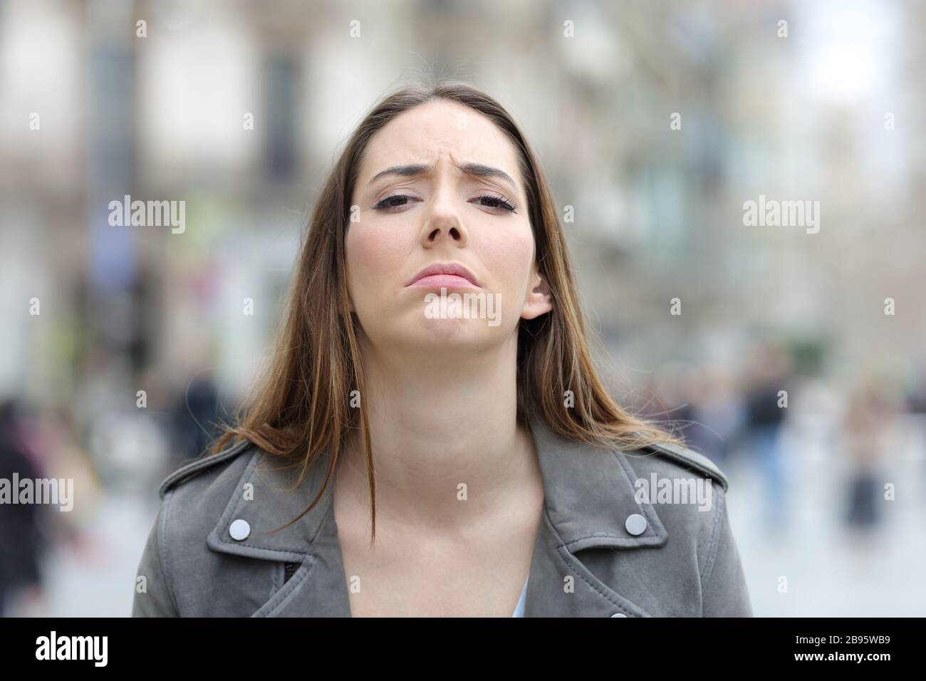 Front view portrait of a disappointed woman looking at camera on a city street Stock Photo