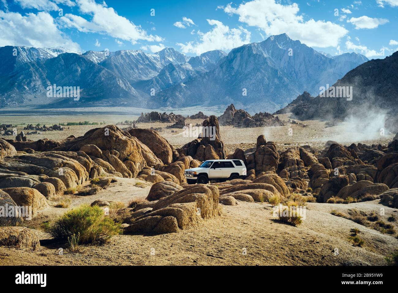 Isolated car camper sits parked against a dramatic mountain background in the Eastern Sierras on a sunny summer day. Stock Photo
