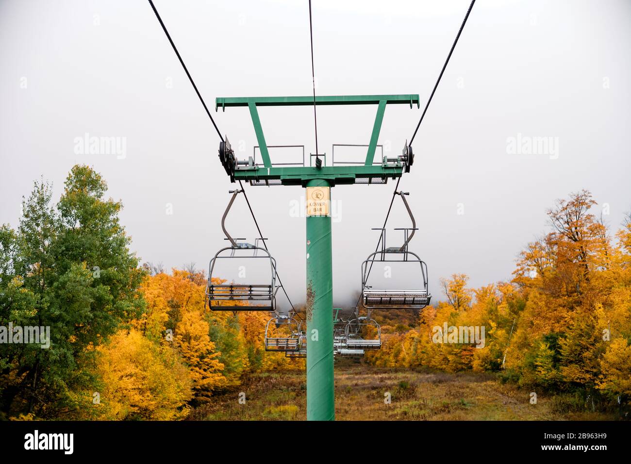 Vacant chairlift at ski resort during peak autumn foliage in Vermont. Stock Photo