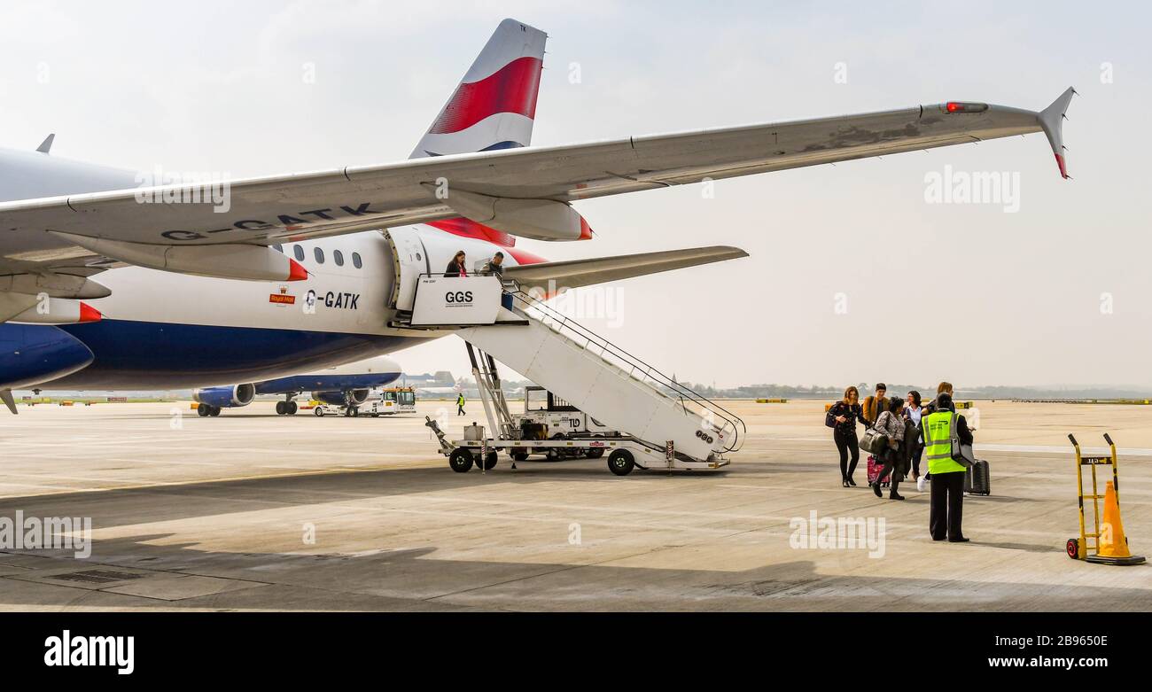 LONDON GATWICK AIRPORT, ENGLAND - APRIL 2019: Passengers disembarking a British Airways Airbus after arriving at London Gatwick Airport Stock Photo